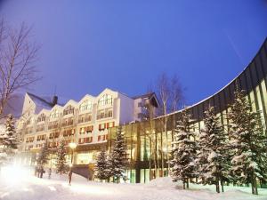 a large building in the snow at night at Rusutsu Resort Hotel & Convention in Rusutsu