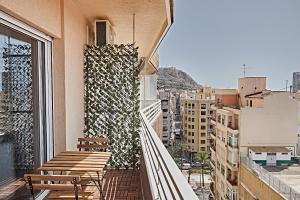 a balcony with benches and a view of a city at Beferent Riscal 3 Alicante Centro in Alicante