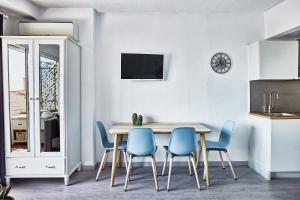 a kitchen and dining room with a table and blue chairs at Beferent Riscal 3 Alicante Centro in Alicante