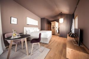 Habitación de hotel con cama, mesa y silla en Hotel Lamm, en Castelrotto