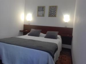 a bedroom with a large bed with two pillows at Aconchego do Lar in Geres