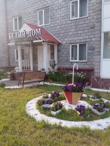 a building with a flower garden in front of it at Bely Dom Hotel in Krasnoyarsk