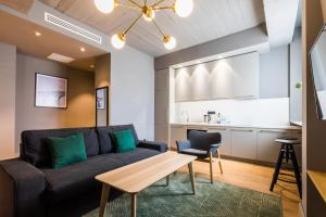 a living room with a couch and a table and a kitchen at HOME/tbilisi in Tbilisi City