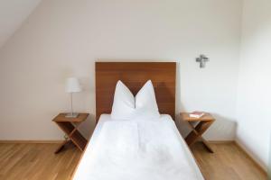 ein Schlafzimmer mit einem großen weißen Bett mit zwei Tischen in der Unterkunft Akademie der Dioezese Weingarten in Weingarten