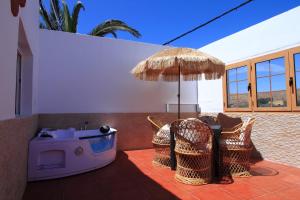 un patio con mesa, sillas y sombrilla en MONTAÑA VALLES DE ORTEGA -D en Antigua