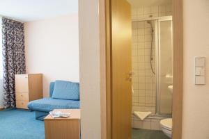 a bathroom with a blue chair and a shower at Werrapark Resort Hotel Heubacher Höhe in Masserberg