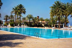 a large swimming pool with palm trees in a resort at Portemilio Hotel & Resort in Jounieh