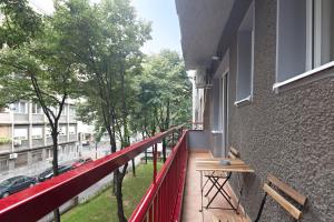 einen Balkon mit rotem Geländer und Straßenblick in der Unterkunft Belgrade Center Apartment IV in Belgrad