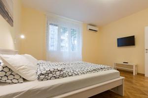 ein Schlafzimmer mit einem Bett und einem TV an der Wand in der Unterkunft Belgrade Center Apartment IV in Belgrad
