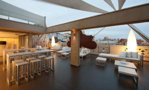 a balcony with tables and chairs on a building at Hotel Constanza in Barcelona