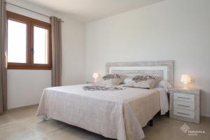 a white bedroom with a bed and a window at Moli den Sion in Sa Pobla +22 photos
