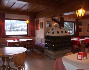 a restaurant with a fireplace in the middle of the room at B&B Bucaneve in Vigo di Fassa