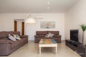 a living room with two brown couches and a coffee table at Moli den Sion in Sa Pobla