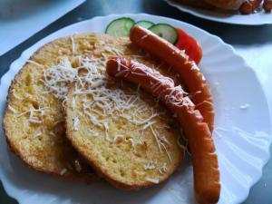 um prato branco com um cachorro quente num pão em Hotel Oroszlán Szigetvár em Szigetvár