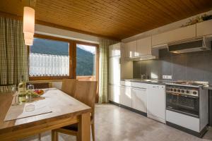 a kitchen with white appliances and a wooden ceiling at Grübelspitz in Tux