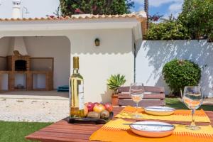 a table with a bottle of wine and two glasses at Villa Paraiso da Luz by Seewest in Luz