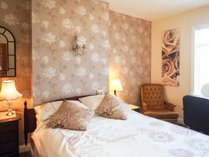 a bedroom with a bed and a chair at Leaded Light Guest House in Solihull