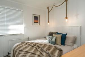 1 dormitorio con 1 cama con manta y almohadas en Feathertop Alpine Lodge, en Falls Creek
