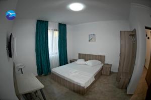 a bedroom with a bed and a green curtain at Casa Sagrada in Eforie Nord