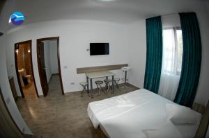 a bedroom with a bed and a table and a television at Casa Sagrada in Eforie Nord