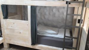 a bunk bed with a ladder in a room at Wellenkind Surfschool in La Pared