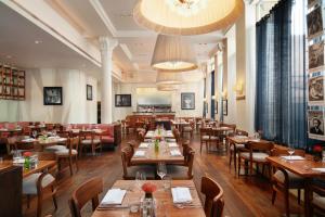 um restaurante com mesas e cadeiras de madeira e uma sala de jantar em Hard Days Night Hotel em Liverpool