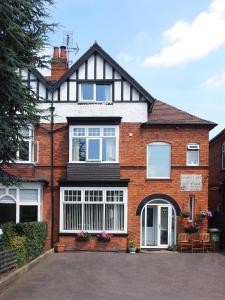 a large red brick house with white windows at Leaded Light Guest House in Solihull