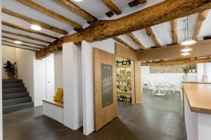 a room with white walls and wooden ceilings at Hostel.B in Belorado