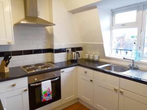 a kitchen with white cabinets and a sink and a window at Manor Suite Apt 2 Bed Apt Central Headington close to Oxford Hospitals in Oxford