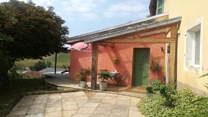 a building with a green door and a patio at Gîte de Lolotte et Gégé in Audeux