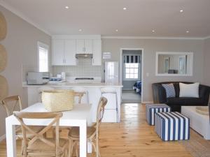 a kitchen and living room with a table and chairs at Kenjockity Self Catering Apartments in Hermanus