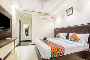 Schlafzimmer mit einem Bett und einem Flachbild-TV in der Unterkunft FabExpress Le Continental in Neu-Delhi