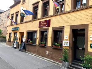a building with flags on the side of it at Hotel Zur Dorfschänke in Klotten