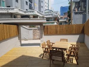 Une table et des chaises en bois sont disponibles sur la terrasse. dans l'établissement Seoul Forest Stay, à Séoul