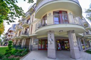 a large building with a balcony on top of it at Apartamenty na Wyspie - Róża Wiatrów in Świnoujście