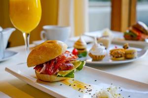 a sandwich on a plate next to a glass of orange juice at Hotel de la Cañada in Córdoba