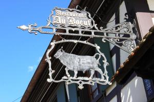 a black and white cat standing on top of a street sign at Hôtel Restaurant Au Boeuf in Blaesheim