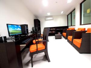 a room with a desk with a computer and orange chairs at Kacha Resort & Spa, Koh Chang in Ko Chang