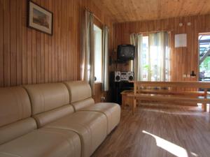 a living room with a couch and a tv at Hostel Livonija in Sigulda