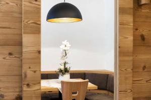 une salle à manger avec une table et une lumière noire dans l'établissement Residence Rottonara, à Corvara in Badia