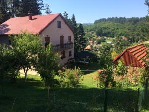 a house with a red roof on a green field at Apartments Popovic in Kola&scaron;in