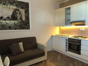 uma sala de estar com um sofá e uma cozinha em Camaldoli House em Milão
