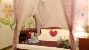 a bedroom with a bed with a canopy with a stuffed animal at sweet home B&B in Hualien City