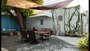 a table and chairs under a tree in a yard at Calle Hollanda 3 Bedroom Home in San Juan