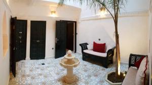 ein Wohnzimmer mit einem Stuhl und einem Baum in der Unterkunft Riad Africa in Marrakesch