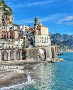 a building on top of a mountain next to the water at La Califfa in Vietri sul Mare