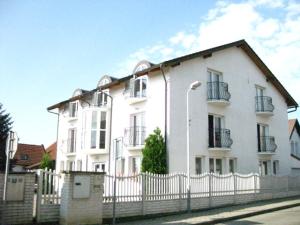 ein weißes Haus mit einem Zaun davor in der Unterkunft Penzion Ariane in Prag