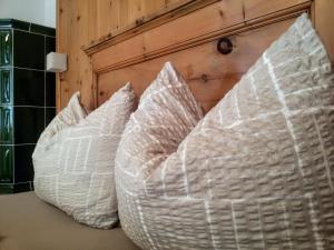 2 almohadas blancas junto a una pared de madera en Casa Zebrusius - Bepi&Piera's Suite, en Valfurva