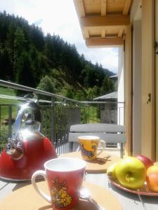 a tea kettle and plates of fruit on a table on a balcony at Casa Zebrusius - Bepi&Piera's Suite in Valfurva