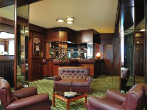 a lobby with a leather couch and a bar at Hotel & Residence Dei Duchi in Urbino